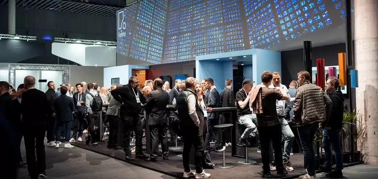 Visitors and loudspeaker displays at a Fohhn exhibition stand.